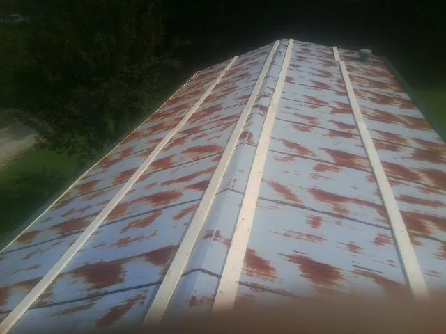 Rusted metal roof panels with new wood purlins before replacement — Storm Damage Roof Repair in Oviedo by Roofing Brothers