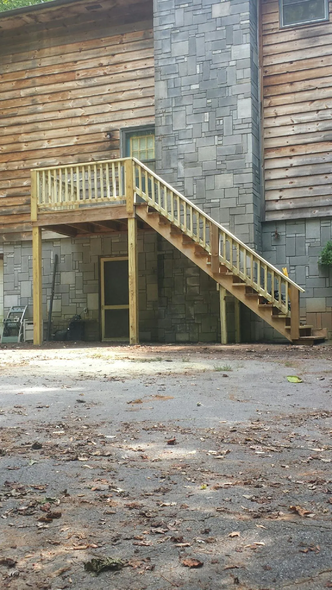 New pressure treated deck and stair landing on a log home in Oviedo