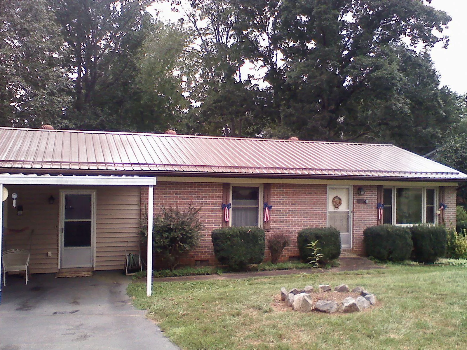 Bronze metal roof and carport on a brick ranch home — Roof Repair work by our crew in Oviedo